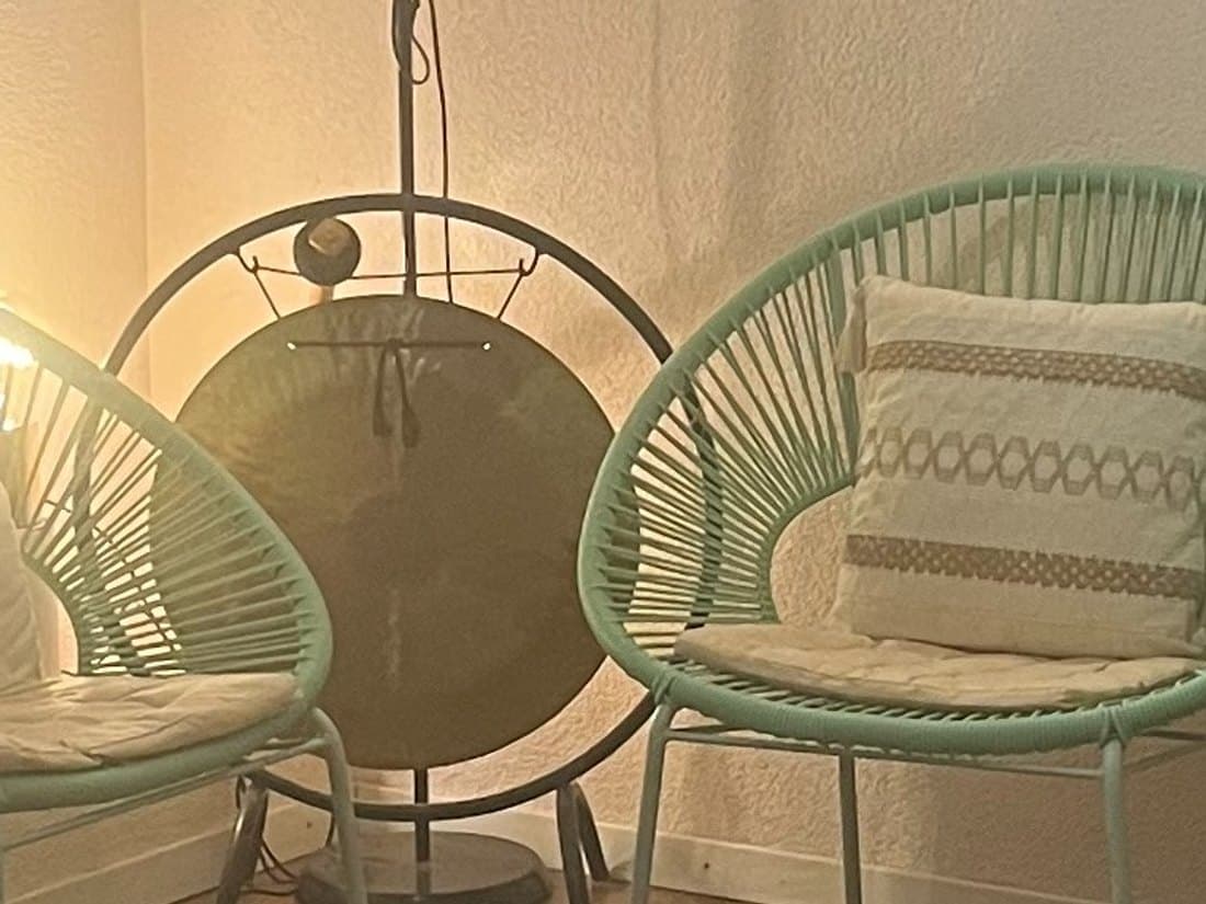Le gong du cabinet, entre deux fauteuils vert d'eau
